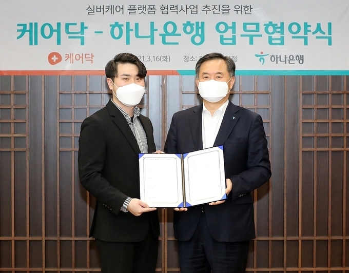 지난 16일 하나은행 본점에서 열린 업무협약식에서 박지환 하나은행 CIB그룹 부행장(사진 오른쪽)과 박재병 케어닥 대표가 기념촬영을 하고 있습니다. 사진ㅣ하나은행