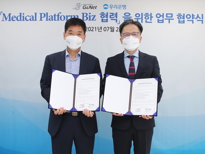 우리은행은 지난 26일 서울 중구에 위치한 지앤넷 회의실에서 지앤넷과 의료 플랫폼 사업모델 개발 업무제휴를 맺었습니다. 황원철(오른쪽) 우리은행 디지털그룹장과 김동헌 지앤넷 대표가 기념촬영을 하고 있는 모습. 사진ㅣ우리은행