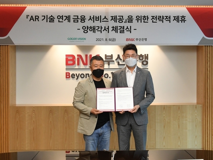 (오른쪽부터)이주형 부산은행 디지털금융본부장, 최영주 코코아비전 대표이사가 기념촬영하는 모습. 사진ㅣBNK부산은행