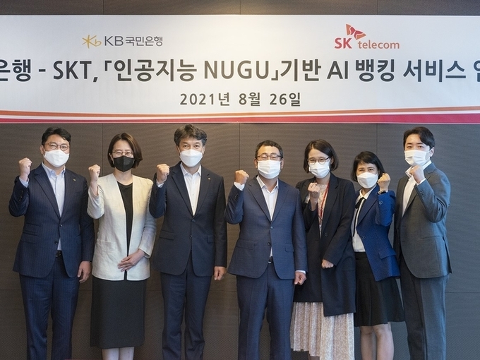  26일 서울 중구 SKT 본사에서 진행된 'KB국민은행-SKT 인공지능 누구 기반 AI뱅킹 서비스 업무 협약식'에서 성채현 KB국민은행 개인고객그룹 대표(왼쪽 세번째)와 유영상 SK텔레콤 MNO사업대표(오른쪽 네번째)가 기념촬영을 하고 있는 모습. 사진ㅣKB국민은행
