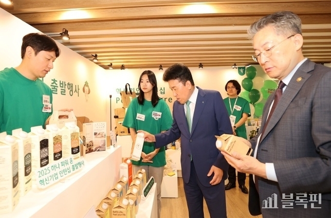 2025 하나파워온 혁신기업 인턴십 출발행사에서 함영주 하나금융그룹 회장(왼쪽 세번째), 김민석 고용노동부 차관(오른쪽)이 행사장에 마련된 사회혁신기업 전시부스를 찾아 기업 소개와 제품에 대한 설명을 듣고 있다. 사진ㅣ하나금융그룹