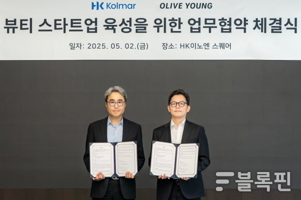 허현행 한국콜마 경영기획본부장(사진에서 왼쪽)과 장지민 CJ올리브영 경영지원담당이 MOU 행사 중 기념 사진을 찍고 있는 모습 사진|올리브영