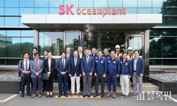경남 고성군 소재 SK오션플랜트 본사를 방문한 로버트 E. 스미스 제너럴다이내믹스 마린 시스템 부회장(사진 첫줄 왼쪽에서 6번째)과 박인식 DSEC 사업개발실장이 이승철 SK오션플랜트 대표이사(사진 첫줄 왼쪽에서 7번째) 등 회사 관계자들과 기념촬영을 하고 있다. 사진|SK오션플랜트