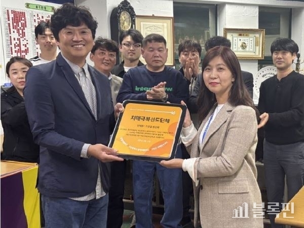 기장군치매안심센터 관계자가 기장읍청년회와 케어링에 치매극복선도단체 지정패를 전달하고 있다. 사진ㅣ기장군 