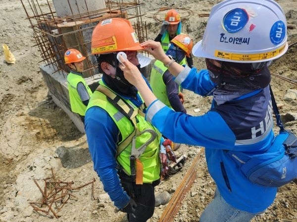 DL이앤씨 현장 안전보건관리자가 근로자의 체온을 측정하고 건강상태를 확인하고 있다. 사진ㅣDL이앤씨 