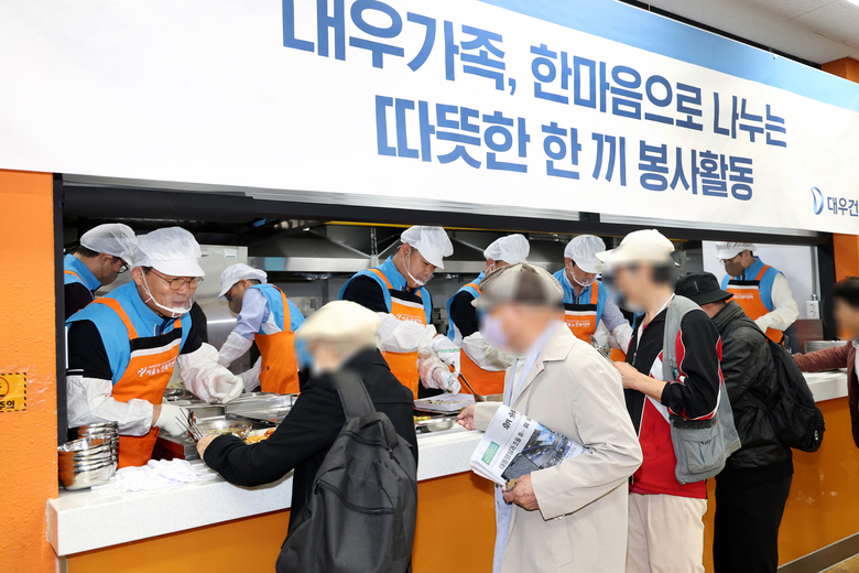 대우건설 김보현 대표이사(왼쪽)와 심상철 노동조합 위원장(오른쪽)이 무료 급식 봉사활동에 참여하고 있다. 사진ㅣ대우건설 